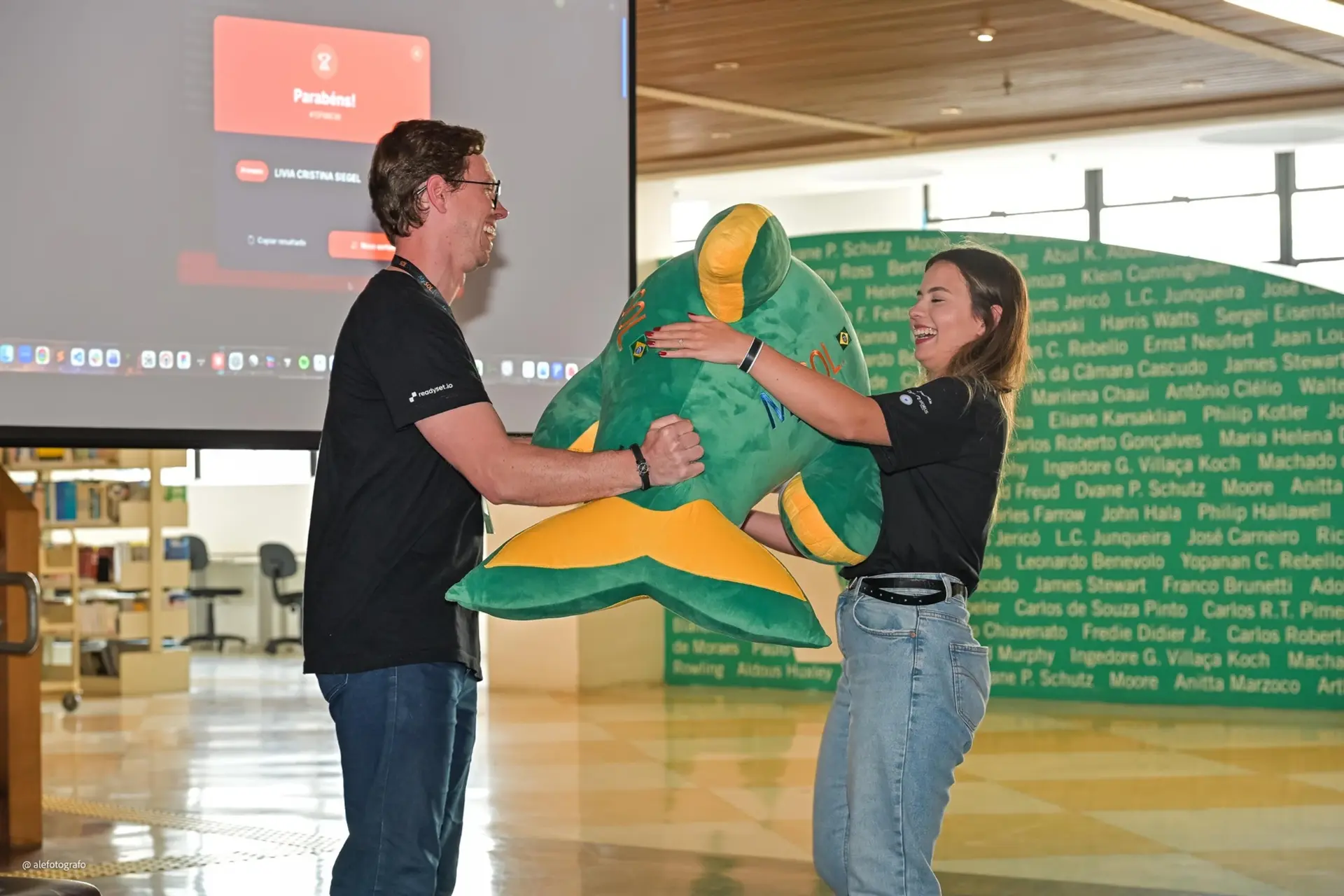 Participante recebendo o golfinho da MySQL BR Conf 2026